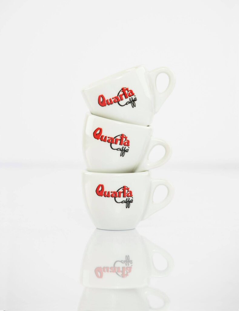 Quarta Caff&egrave;, pila di tazzine con il logo