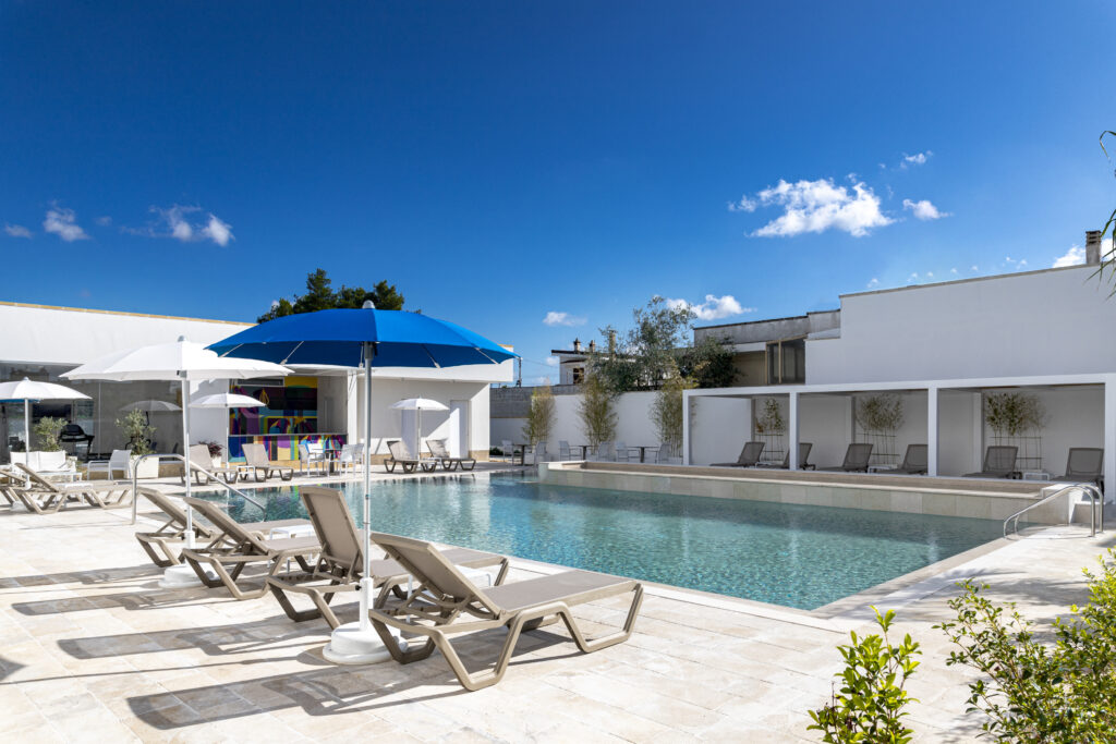 Azzurra Apart Hotel, piscina con lettini e ombrellone blu