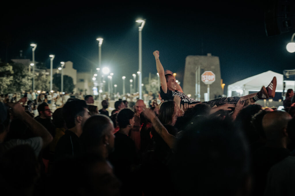 Pubblico di Surfest davanti al palco sul lungomare di San Foca di notte