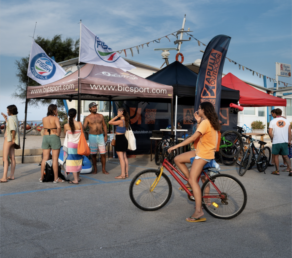 Stand e biciclette sul lungomare di San Foca durante Surfest
